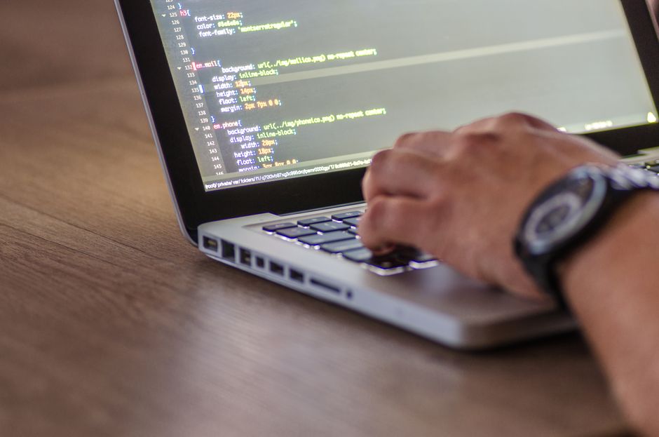 A close-up shot of a person coding on a laptop, focusing on the hands and screen. — illustrating claude code to figma