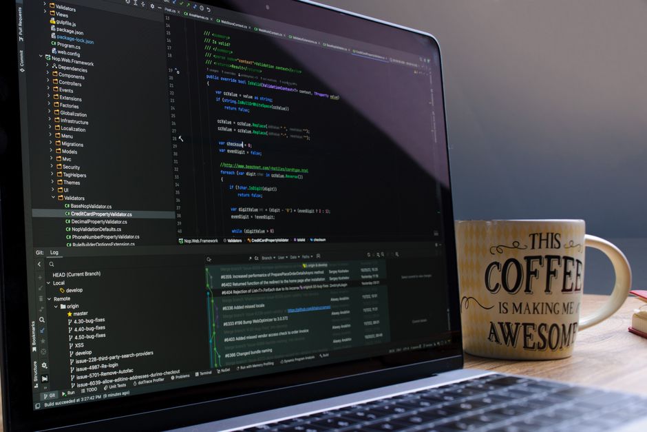 Close-up of laptop with coding software and a motivational coffee mug on a desk. — illustrating claude code web